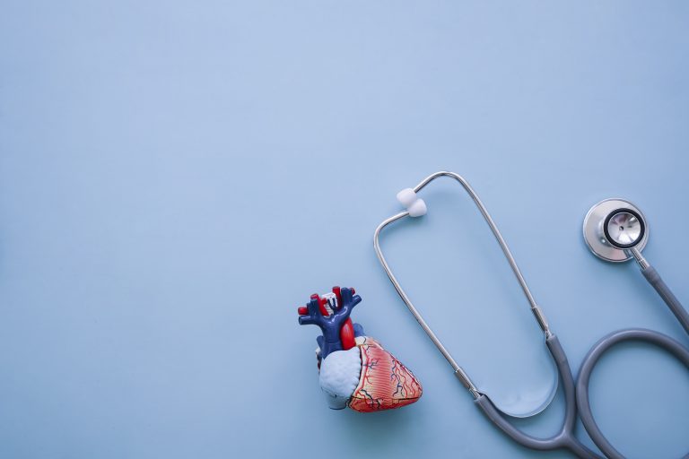 Image of a stethoscope and heart model on a blue background.